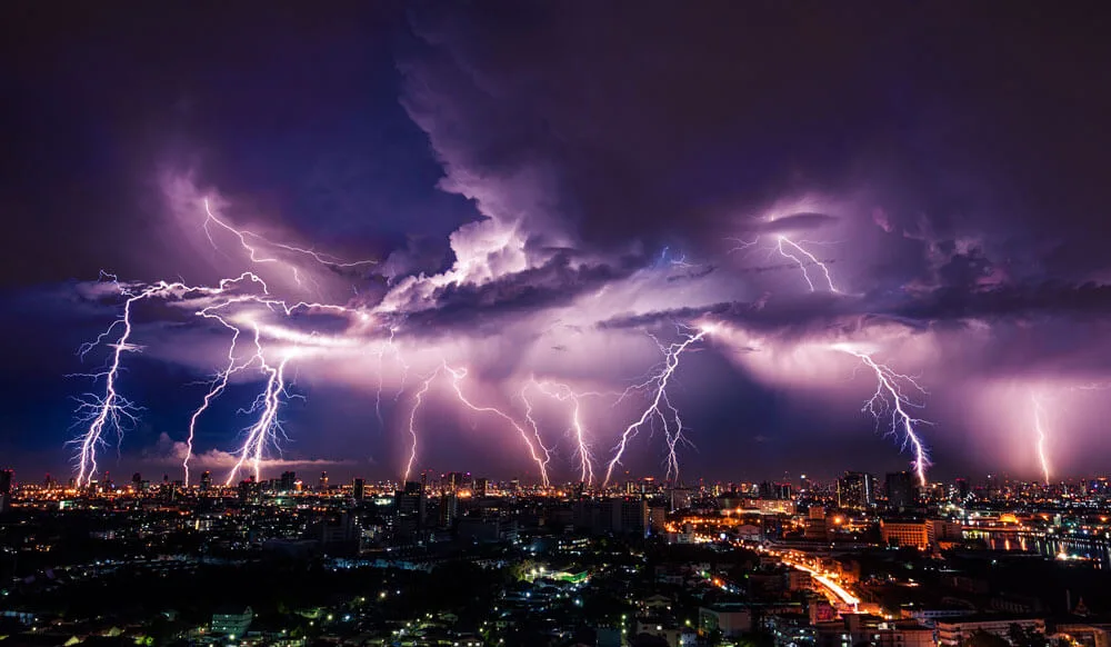 lightning lighting in the sky over a city